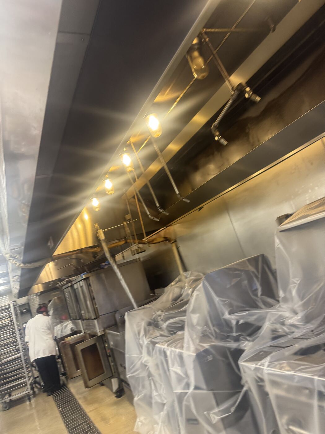 Technicians servicing hood system in commercial kitchen